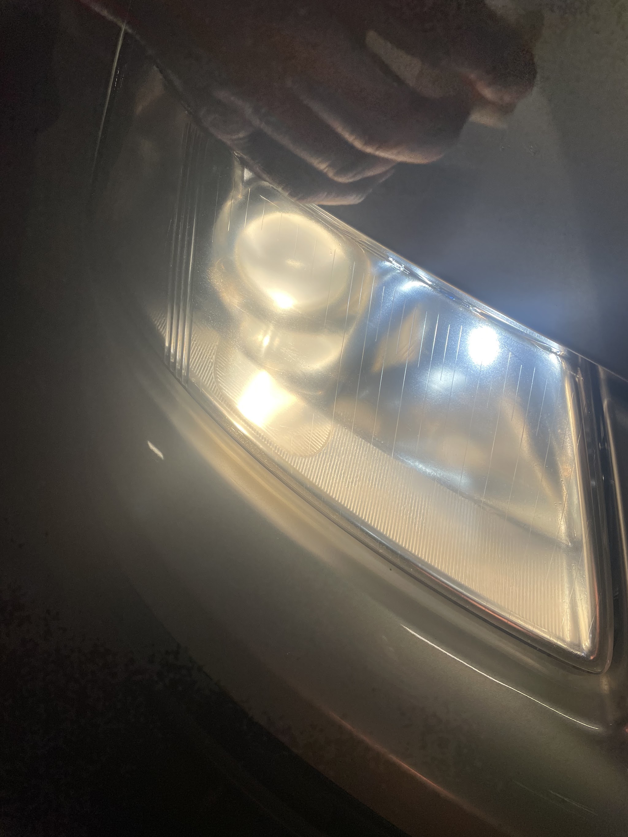 Close-up of a restored headlight lens on the same car