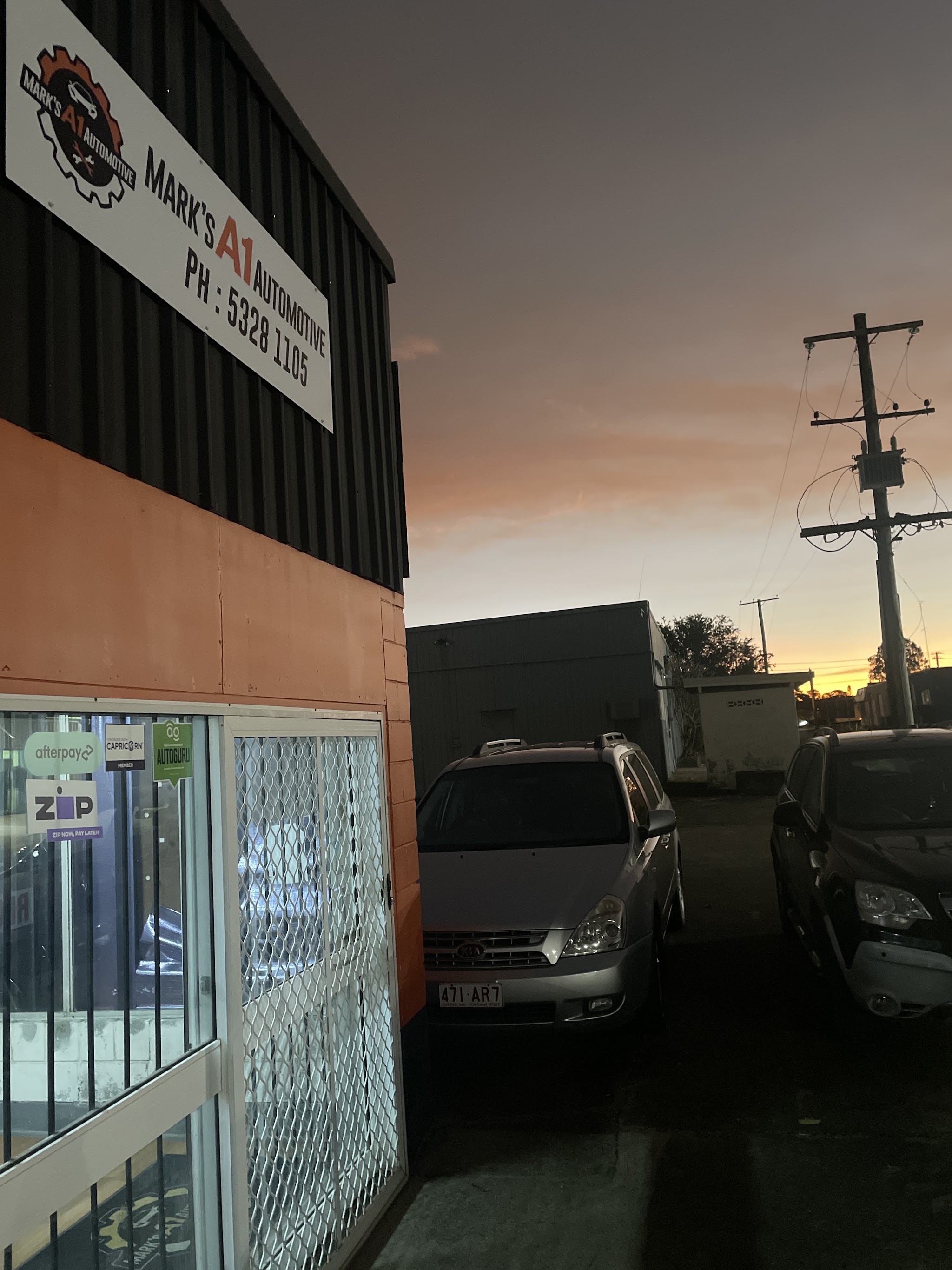 Mark's A1 Automotive workshop on Morayfield Rd at dusk, with the orange and black shopfront and signage